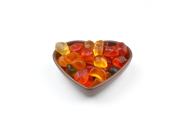 bonbons sucrés multicolores dans un bol en forme de cœur sur fond blanc vue supérieure Espace pour le texte