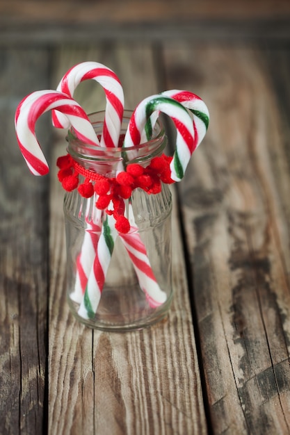 Bonbons sucrés de Noël dans le verre sur le fond, vertical