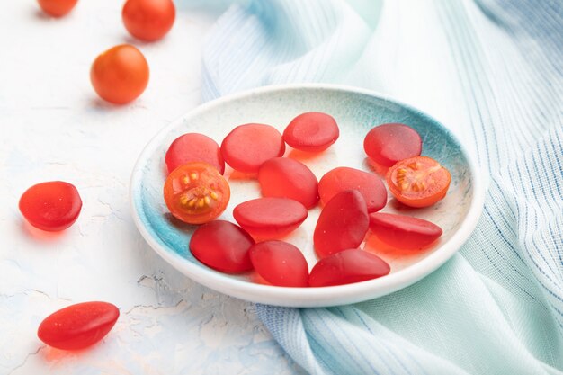 Bonbons à la tomate gelée sur fond de béton blanc