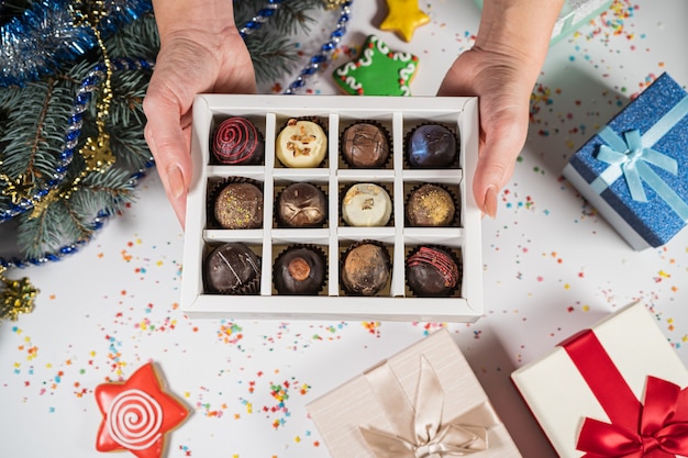 Bonbons à la truffe au chocolat faits à la main dans une boîte blanche sur fond de Noël. Directement au-dessus de la vue de dessus.