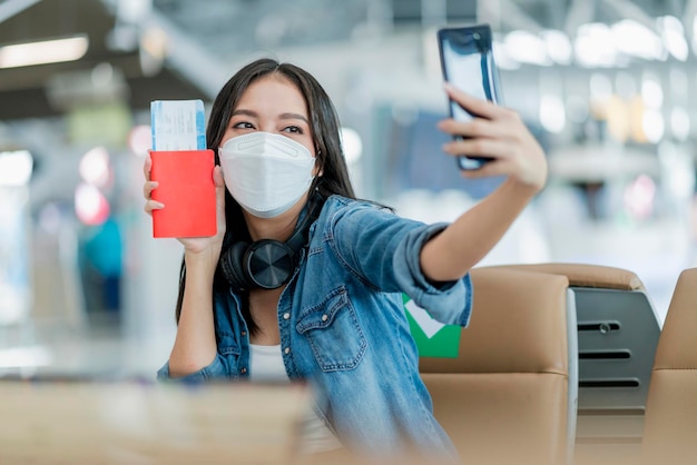 Bonheur femme asiatique prendre selfie phot avec passeport et billet d'avion prêt à voyager