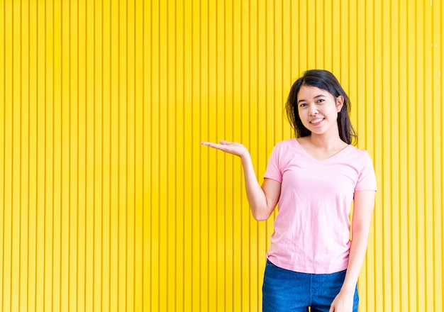 bonheur de jeune femme asiatique debout sur le mur jaune