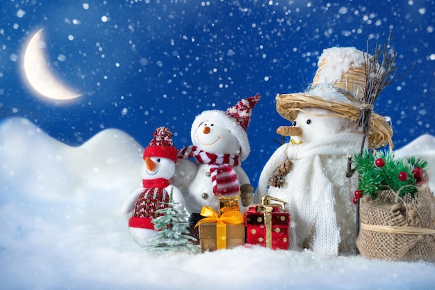 Bonhomme de neige dans une congère avec des cadeaux pour Noël et nouvel an