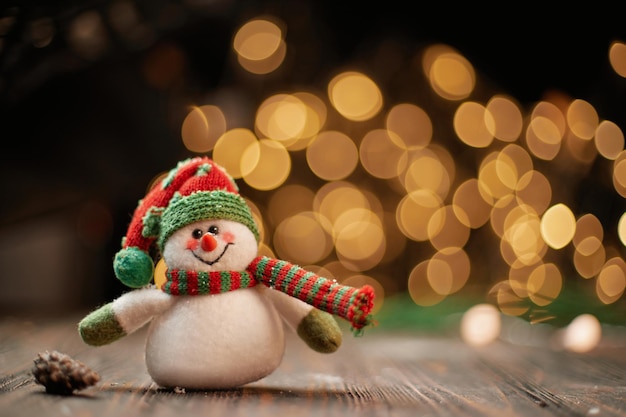 Bonhomme de neige jouet sur fond de lumières de Noël. photo avec un espace de copie.