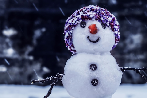 Bonhomme de neige souriant au chapeau chute de neige sur fond sombre