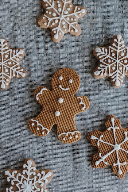 Bonhomme de pain d'épice de Noël et biscuits de flocons de neige sur fond de toile de lin neutre Vue de dessus à plat