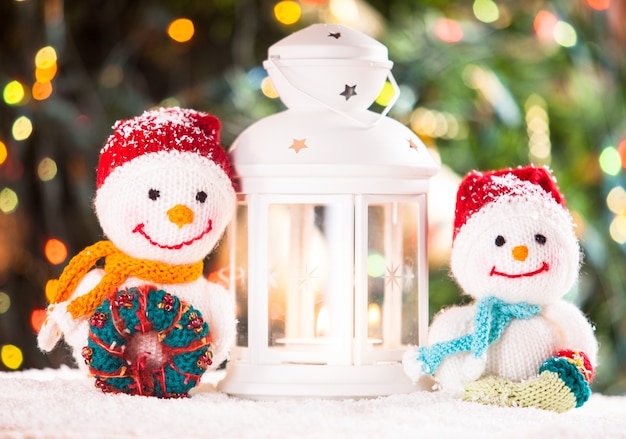 Bonhommes de neige tricotés et lanterne-chandelier de Noël - décorations pour la maison sur la neige
