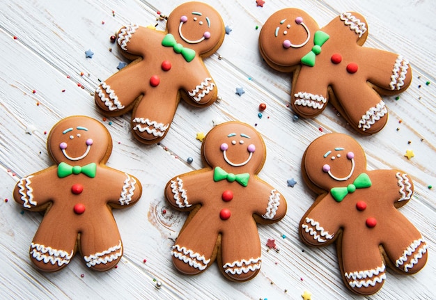 Bonhommes De Pain D'épice De Noël Sur Un Fond En Bois Blanc. Délicieux Pain D'épice De Noël Fait Maison