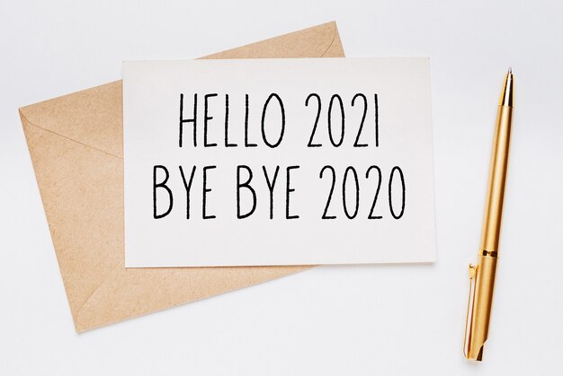 Bonjour 2021 bye bye 2020 note avec enveloppe et stylo or sur fond blanc. joyeux noël et nouvel an concept