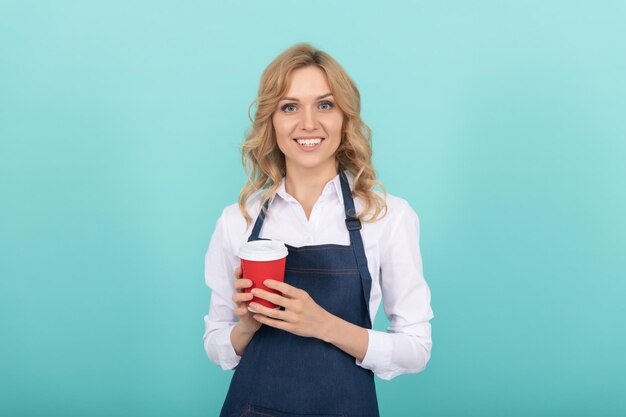 Bonjour. exprimer le bonheur. Émotions positives. portrait de plaisir. un barista heureux boit du café. boisson à emporter. fille joyeuse buvant du thé. femme en tablier avec gobelet en plastique.