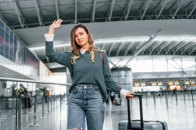 Bonjour geste Jeune femme touriste est à l'aéroport pendant la journée