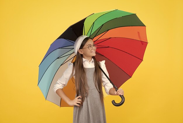 Bonne adolescente sous un parapluie coloré pour la protection contre la pluie en automne protection contre la pluie