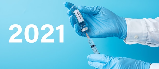 Bonne année 2021 avec le flacon de vaccin COVID-19 et la seringue à aiguille d'injection contre le coronavirus