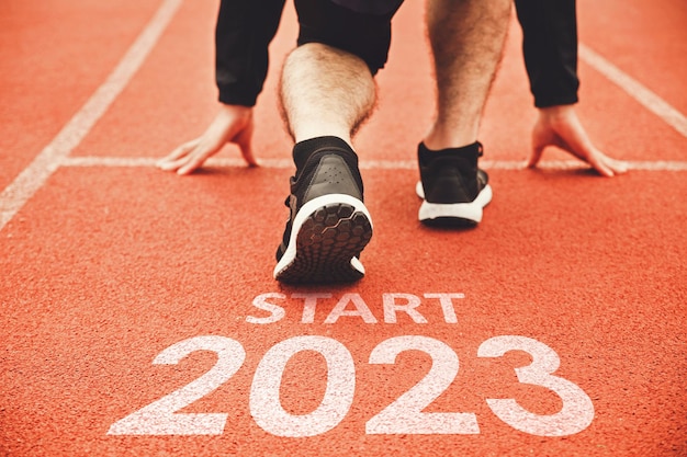 Bonne année 2023 2023 symbolise le début de la nouvelle année Vue arrière d'un homme se préparant à courir