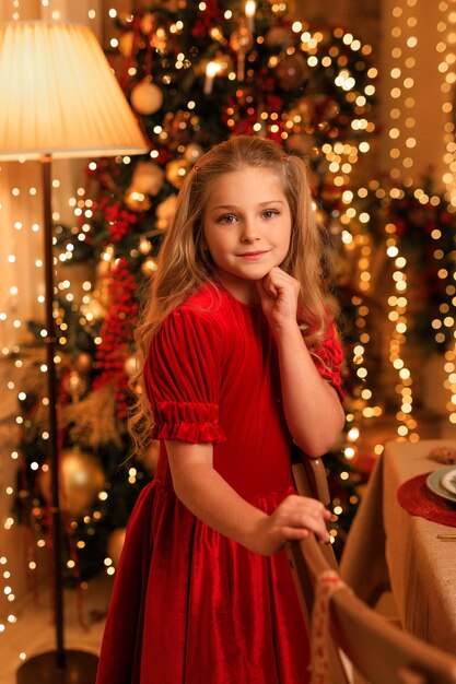 Bonne année! belle fille près de la table de Noël