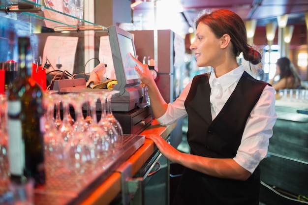 Bonne barmaid en utilisant l&#39;écran tactile jusqu&#39;à