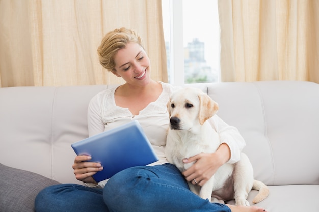 Bonne blonde à l&#39;aide de tablet pc avec chiot