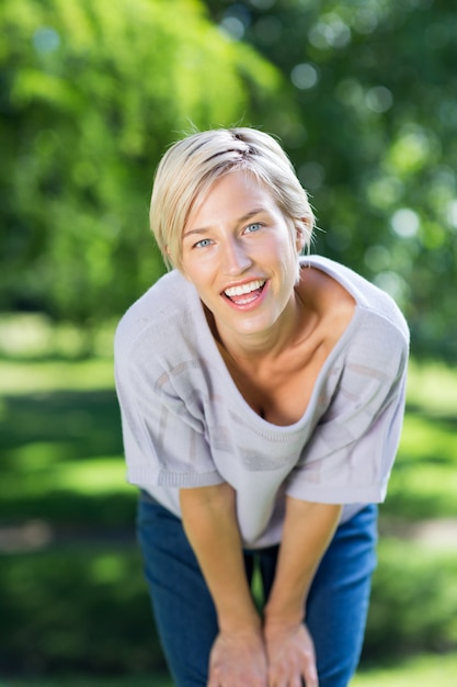 Bonne blonde souriante à la caméra