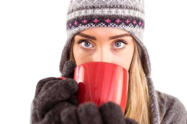 Bonne blonde en vêtements d&#39;hiver tenant la tasse