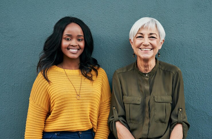 Photo bonne diversité et portrait de femmes sur fond bleu pour le succès, le bonheur et le travail sourire d'affaires et un jeune et senior employé debout sur un mur pour une pause professionnelle