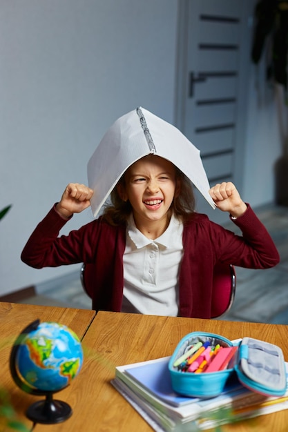 Bonne écolière smart girl bras mettre classeur sur la tête