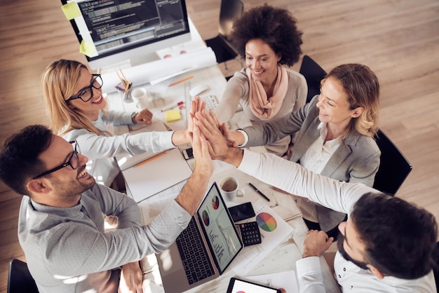 Bonne équipe d'affaires donnant un high five au bureau