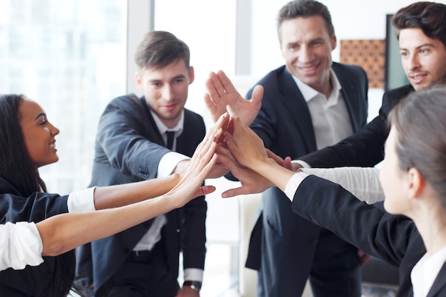 Bonne équipe commerciale faisant cinq avec leurs mains au bureau