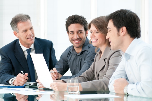 Bonne équipe commerciale souriante travaillant ensemble au bureau