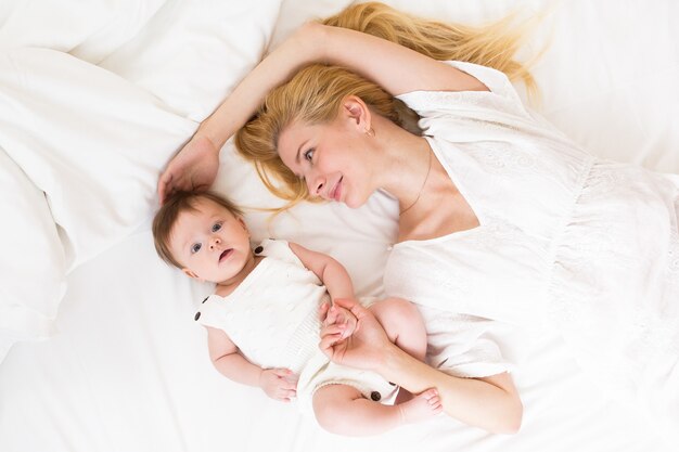 Bonne famille aimante. mère jouant avec son bébé dans la chambre, vue d'en haut.