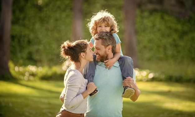 Bonne fête de la famille Mère et père portant son fils sur les épaules Journée de la famille Parents et garçon enfant