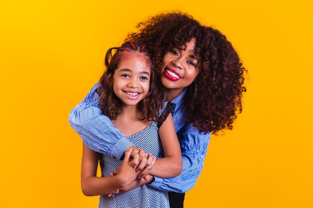 Bonne fête des mères! Adorable jeune mère afro-américaine douce avec une jolie petite fille.