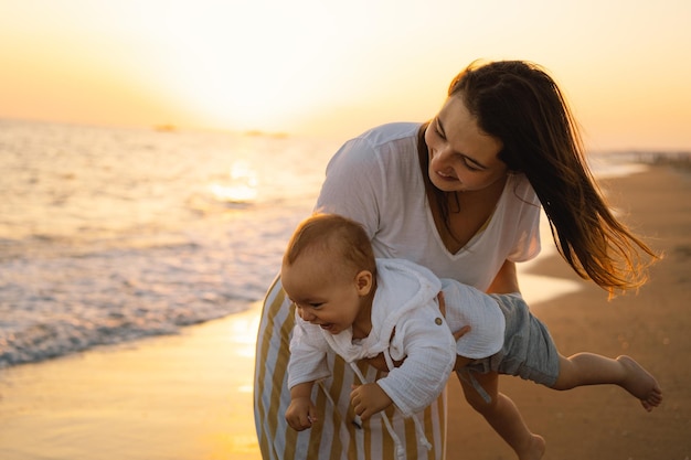 Bonne fête des mères belle mère et bébé jouent sur la plage