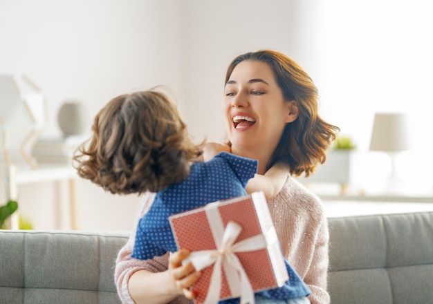 Bonne fête des mères La fille de l'enfant félicite maman et lui offre une boîte-cadeau