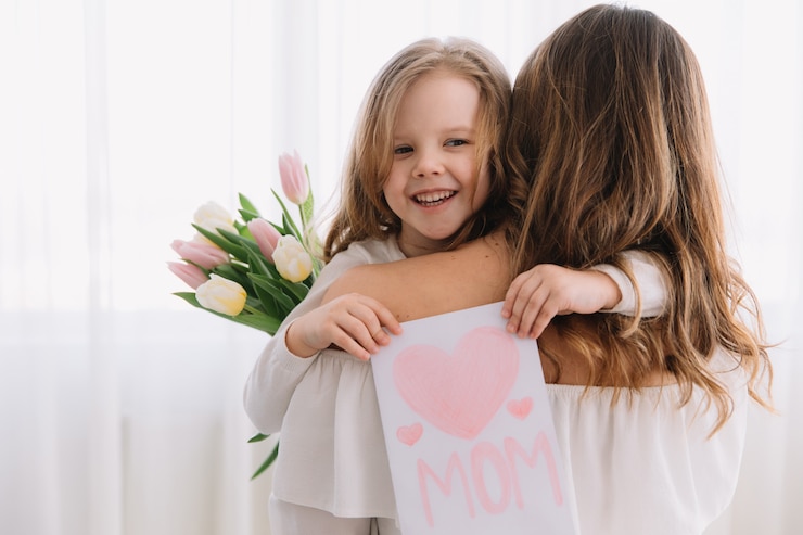 Photo bonne fête des mères. fille enfant félicite les mamans et lui donne une carte postale et des fleurs de tulipes.