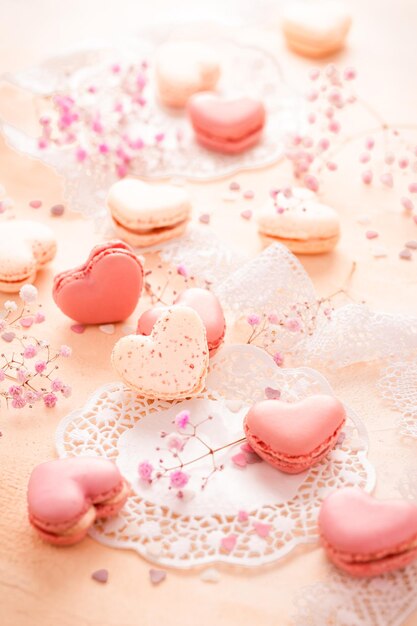 Bonne fête des mères macarons sucrés en forme de coeur avec des fleurs dans les tons roses