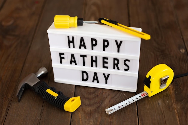 Bonne fête des pères Message lightbox du père avec des outils sur fond de bois Concept de carte de voeux