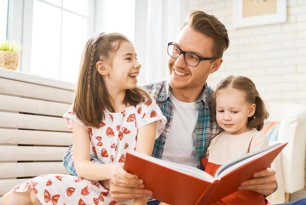 Bonne fête des pères Père lisant un livre à ses filles