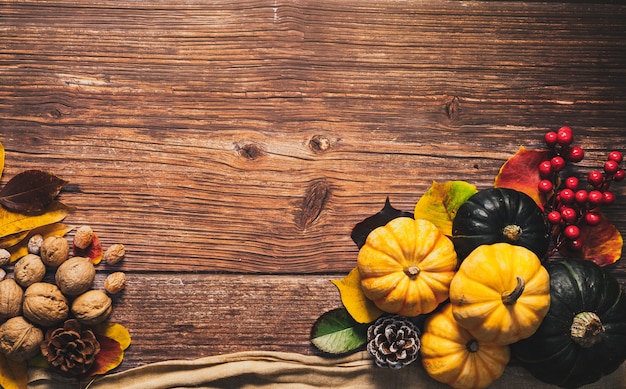 Bonne fête de Thanksgiving avec citrouille et noix sur une table en bois