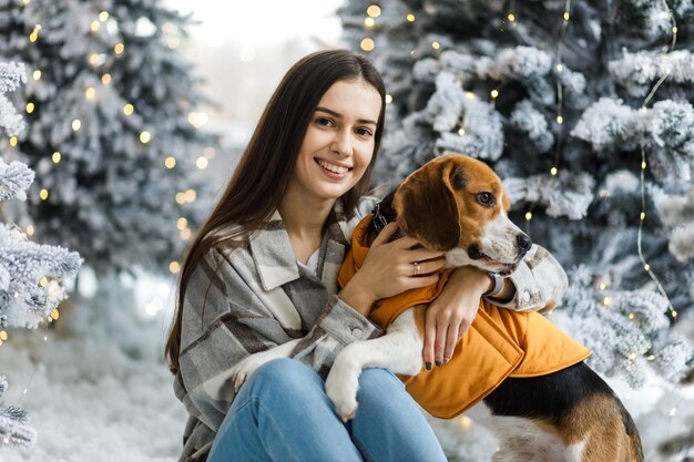 Bonne fille et chien pour Noël Une fille avec un beagle dans une atmosphère du Nouvel An