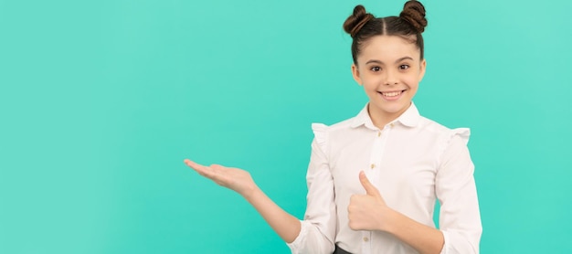 Bonne fille de l'école primaire donne le pouce en l'air montrant le geste de la main ouverte de retour à l'école vente shopping enfant visage affiche horizontale adolescent fille isolé portrait bannière avec espace de copie