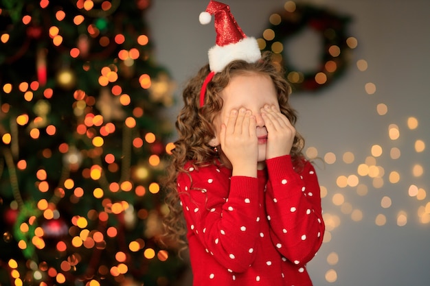 Bonne fille enfant riant avec cadeau de Noël à la maison