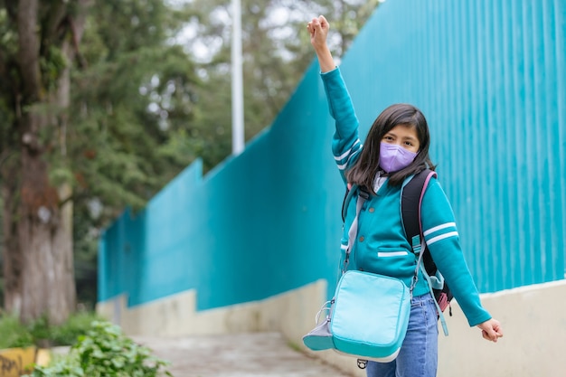 Bonne fille mexicaine excitée à l'école portant un masque protecteur après le verrouillage du coronavirus