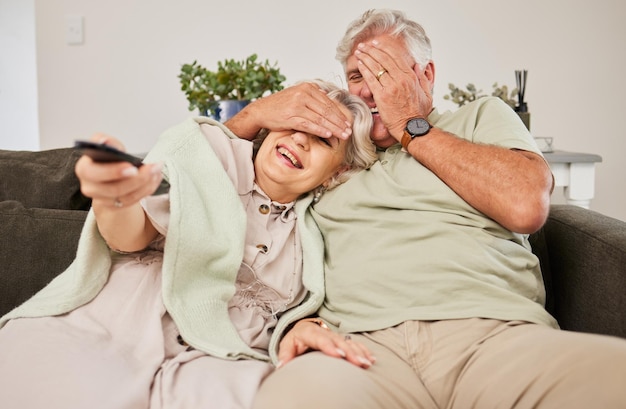 Bonne horreur et regarder la télévision avec un vieux couple sur un canapé pour un abonnement en streaming et un film Peur de la télévision et peur avec un homme et une femme âgés dans le salon à la maison pour filmer et embrasser