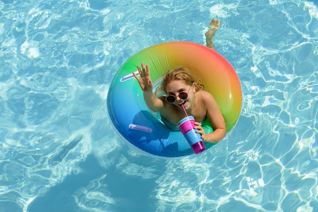 Bonne humeur d'été pool resort profitant de vacances femme en maillot de bain sur un anneau de bain dans la piscine