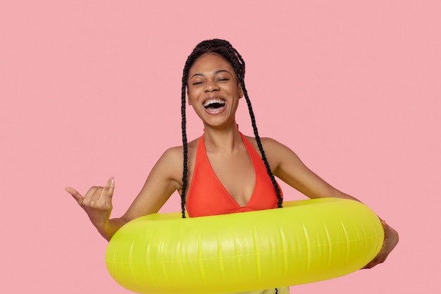 Bonne humeur. Femme afro-américaine souriante tenant un tube jaune et s'amusant