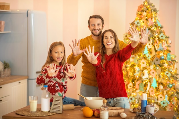 Bonne humeur. Kid et ses parents cuisinent ensemble dans la cuisine et se sentent bien