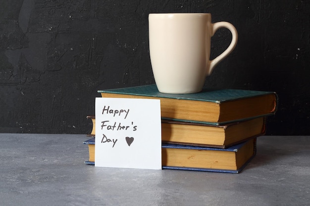 Photo bonne journée des pères avec une tasse de café et des livres sur fond de bois