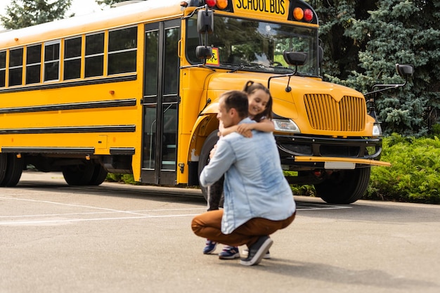 Photo bonne journée de rentrée scolaire. père souriant emmenant son enfant à l'école primaire.