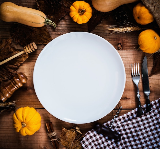 Bonne journée de Thanksgiving. Sans poulet et dinde rôtis. Assiette blanche vide avec décoration citrouille.