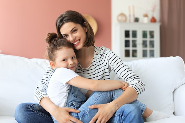 Bonne maman aimante étreignant sa petite fille, passez du temps ensemble à la maison.